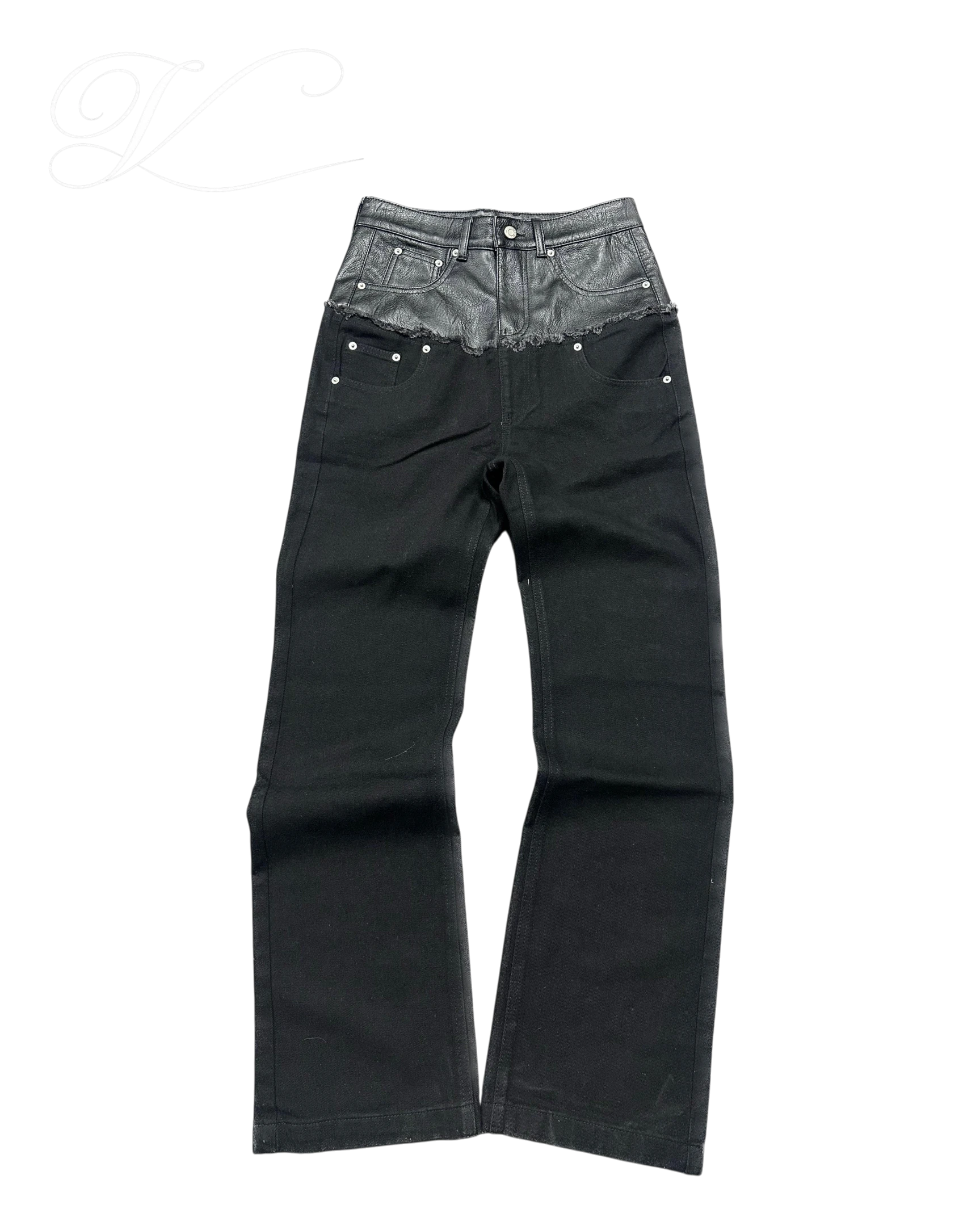 Vicious black denim jeans with a mid-rise waist featuring a contrasting faux leather panel and raw edge detail.