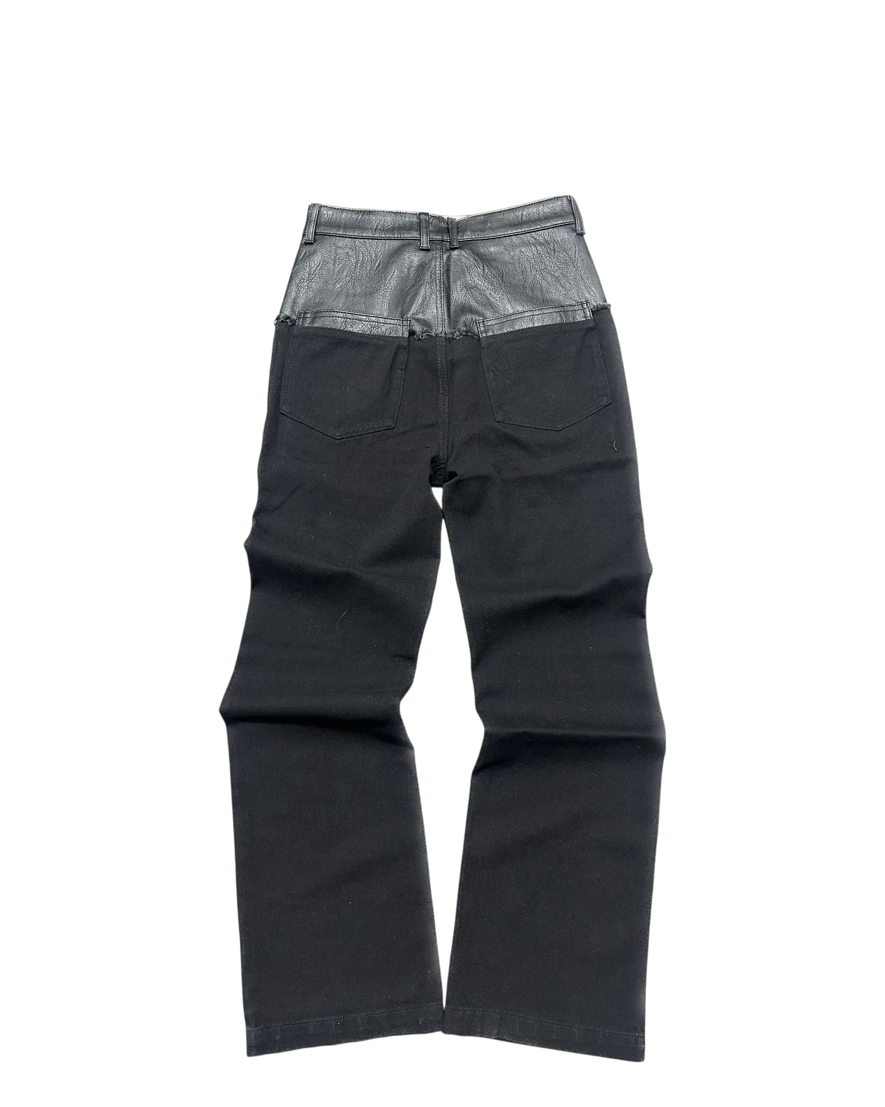 Vicious black denim jeans featuring a unique leather-look contrast waist panel and back pockets.